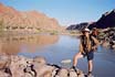 Sheila, complete with umbrella, hiking alongside the Orange River in Augrabies Falls National Park
