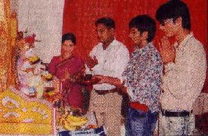 Amit Sana and others of the Radio City channel perform 'Aarti' of an idol of the demon Ganapati in the home of a Ganesh Nikkam, as part of a promotion