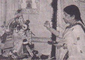 Goan Hindu singer and traitoress Lata Manguescar performing Aarti on an idol of the demon Ganapati