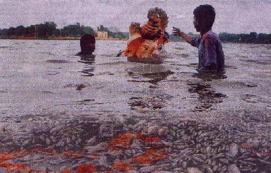 Pagans surrounded by shoals of dead fish attempting to push an idol of the demon Ganapati into deeper waters in the Kankaria Lake, Ahmadabad, Gujarat. The immersion of the idols combined with recent weather changes has depleted the oxygen levels in the lake leading to the fish dying. Associated Free Press photograph published in the D.N.A., Bombay, Sept. 19, 2005