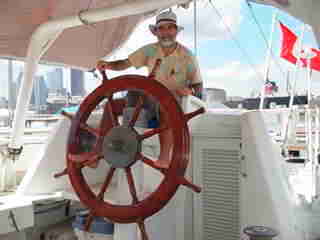 Skipper am antiken Steuerrad der Yacht